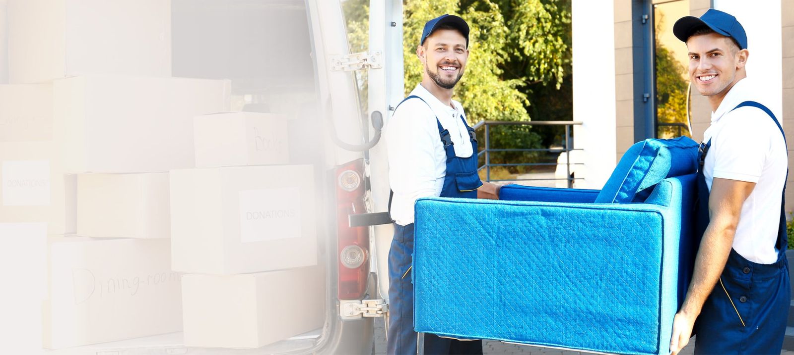 Two VC Movers crew members carrying an armchair to the van